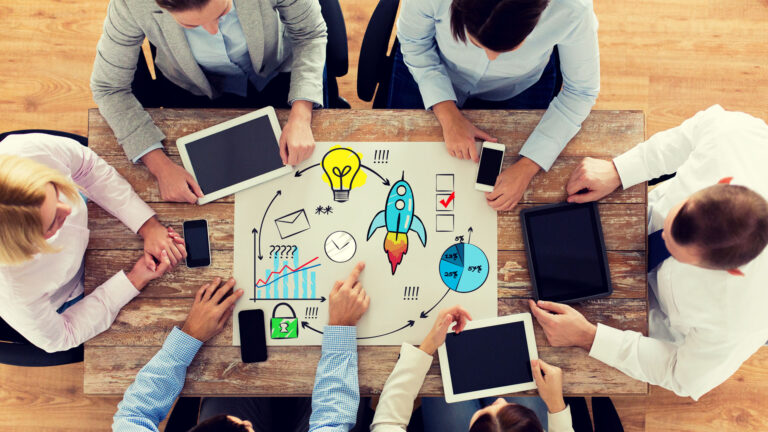 Crypto Services: Team bei der Planung eines Blockchain-Projekts mit Tablets und Smartphones