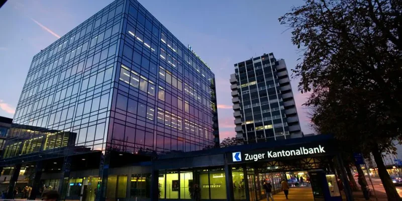 Zuger Kantonalbank Hauptsitz bei Abenddämmerung – Bank erweitert Krypto-Angebot mit Cardano (ADA) und Avalanche (AVAX).